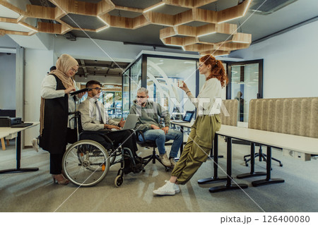 Young group of business people brainstorming together in a startup space, discussing business projects, investments, and solving challenges. Young group of business people brainstorming together in a startup space, discussing business projects, investments, and solving challenges. 126400080