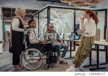 Young group of business people brainstorming together in a startup space, discussing business projects, investments, and solving challenges. Young group of business people brainstorming together in a startup space, discussing business projects, investments, and solving challenges. 126400127