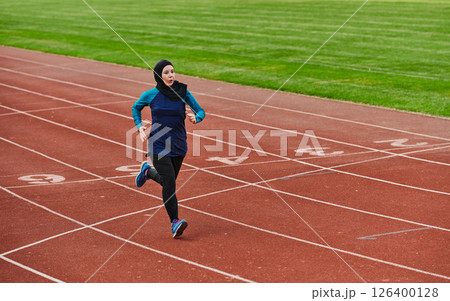 A muslim woman in a burqa sports muslim clothes running on a marathon course and preparing for upcoming competitions A muslim woman in a burqa sports muslim clothes running on a marathon course and preparing for upcoming competitions 126400128