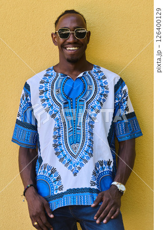 Sudanese Tradition Meets Modern Youth: African American Teen in Vibrant Traditional Attire Against a Yellow Backdrop 126400129