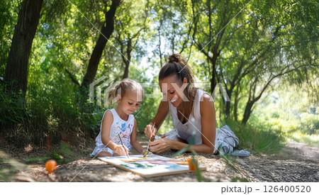A mother and daughter joyfully painting on a canvas during a forest picnic. Generated image 126400520