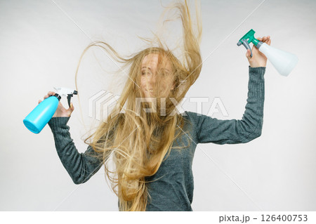 Female messy long hair holds spray bottle Female messy long hair holds spray bottle 126400753