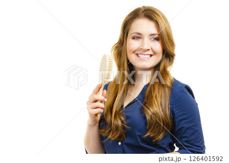 Woman brushing long healthy brown hair 126401592