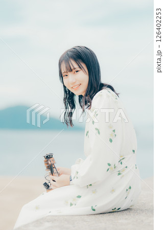 穏やかな海辺で静かに佇む女性とランタン 126402253