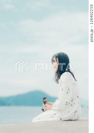 穏やかな海辺で静かに佇む女性とランタン 穏やかな海辺で静かに佇む女性とランタン 126402259