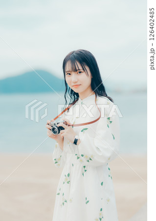 フィルムカメラを持つナチュラルな女性の横顔ポートレート 126402485