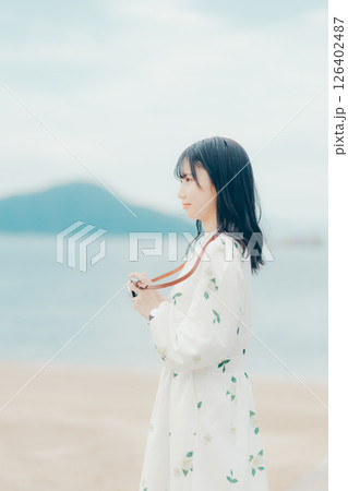 フィルムカメラを持つナチュラルな女性の横顔ポートレート フィルムカメラを持つナチュラルな女性の横顔ポートレート 126402487