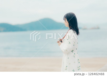 フィルムカメラを持つナチュラルな女性の横顔ポートレート 126402488