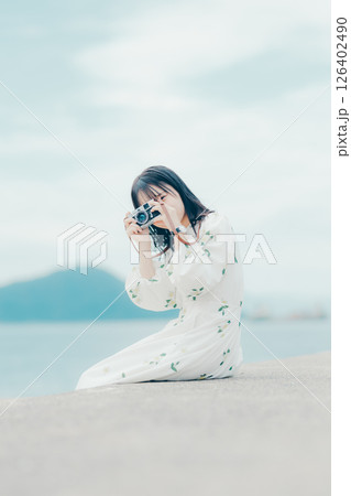 フィルムカメラを持つナチュラルな女性の横顔ポートレート 126402490