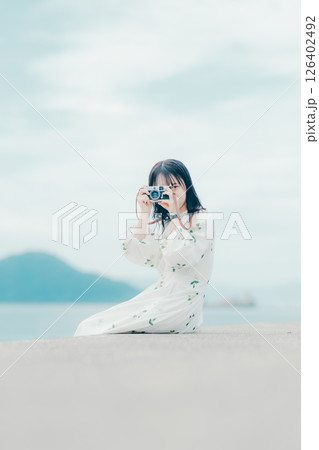フィルムカメラを持つナチュラルな女性の横顔ポートレート フィルムカメラを持つナチュラルな女性の横顔ポートレート 126402492