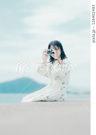 フィルムカメラを持つナチュラルな女性の横顔ポートレート フィルムカメラを持つナチュラルな女性の横顔ポートレート 126402493