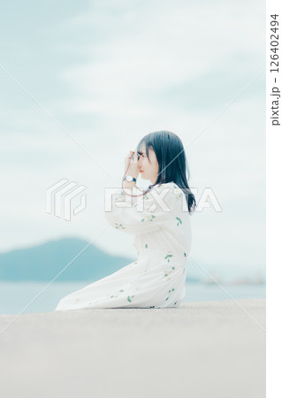 フィルムカメラを持つナチュラルな女性の横顔ポートレート フィルムカメラを持つナチュラルな女性の横顔ポートレート 126402494