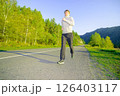 Man jogging in city partk at beautiful summer day. Sport fitness model caucasian ethnicity training outdoor. 126403117
