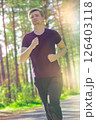 Man jogging in city partk at beautiful summer day. Sport fitness model caucasian ethnicity training outdoor. 126403118
