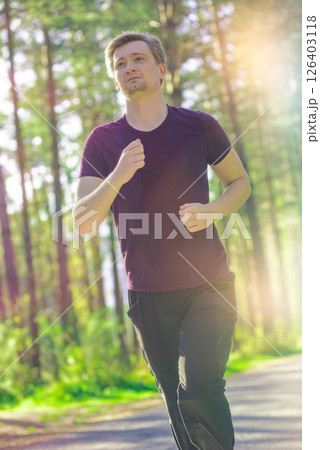 Man jogging in city partk at beautiful summer day. Sport fitness model caucasian ethnicity training outdoor. 126403118