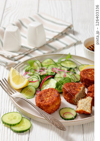 dutch fish cakes with cucumber salad on a plate dutch fish cakes with cucumber salad on a plate 126403336