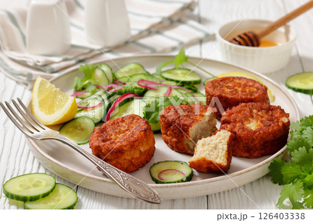 dutch fish cakes with cucumber salad on a plate dutch fish cakes with cucumber salad on a plate 126403338