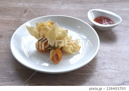 golden bag crispy fried dumpling paste stuffed chop pork and shrimp Thai snack dipping sweet chili plum sauce on cup 126403703