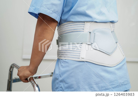 Asian woman wearing lumbar support pain back and use walker in hospital. 126403983