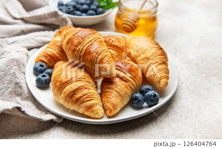 Freshly baked croissants with blueberries and honey for breakfast 126404764