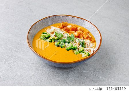 Creamy Pumpkin Soup with Broccoli Chicken Croutons and Parmesan in Ceramic Bowl Creamy Pumpkin Soup with Broccoli Chicken Croutons and Parmesan in Ceramic Bowl 126405339