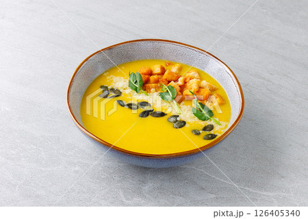 Pumpkin Soup with Croutons Parmesan Seeds and Microgreens in Ceramic Bowl Pumpkin Soup with Croutons Parmesan Seeds and Microgreens in Ceramic Bowl 126405340
