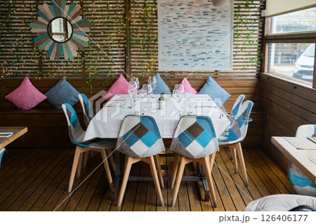 Cozy outdoor dining area with colorful cushions and wooden accents 126406177