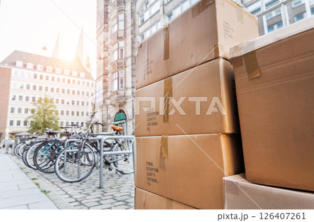 Many paper cardboard boxes on downtown street german city. Parcel delivery shipment courier logistics service. Office or home moving package scene Many paper cardboard boxes on downtown street german city. Parcel delivery shipment courier logistics service. Office or home moving package scene 126407261