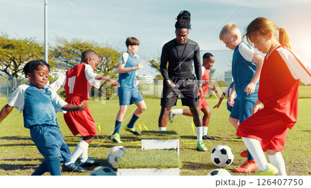 Sports field, soccer player and children with ball, training and athlete with energy for practice in morning. Playing, football and kids with sportswear for game, growth and development with fitness 126407750