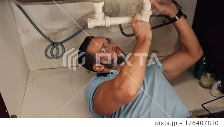 Man, plumber and assessment in kitchen, pipe and sink with search for leak, problem solving and repair in home. Person, handyman and check for water, drain and solution for maintenance at apartment Man, plumber and assessment in kitchen, pipe and sink with search for leak, problem solving and repair in home. Person, handyman and check for water, drain and solution for maintenance at apartment 126407810