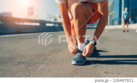 Person, hands or tying shoes in city street for fitness preparation, workout or exercise. Closeup, active or runner getting ready with tie or laces on road for cardio training, sprint or race in town Person, hands or tying shoes in city street for fitness preparation, workout or exercise. Closeup, active or runner getting ready with tie or laces on road for cardio training, sprint or race in town 126407811