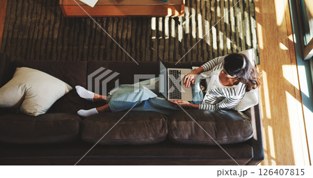 Computer, sofa and above of woman in home for research, browse website and internet, Relax, living room and top view of person on laptop for typing email, connection and communication in house 126407815