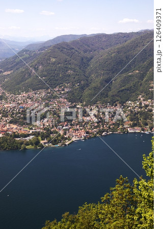 Aerial view of Como city and Lake Como, surrounded by lush hills and mountains, with boats on the water and scenic urban landscape in northern Italy. 126409371