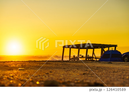 Tent on beach in sunrise light. Tent on beach in sunrise light. 126410589