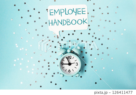 Clock with the words Employee Handbook written above it Clock with the words Employee Handbook written above it 126411477