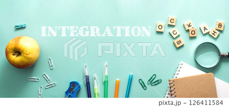 A green background with a bunch of school supplies and an apple 126411584