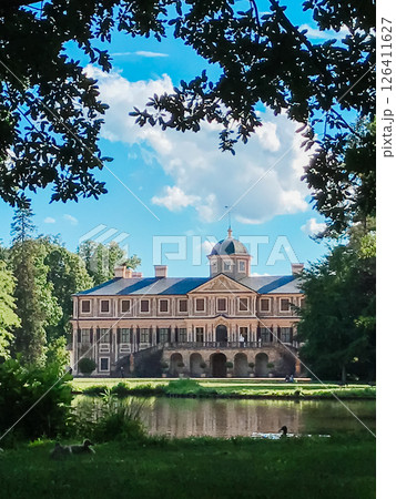 A large house with a large garden and a pond in front of it A large house with a large garden and a pond in front of it 126411627