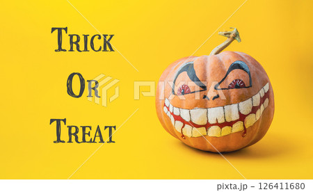 Pumpkin with a scary face and the words trick or treat written below it Pumpkin with a scary face and the words trick or treat written below it 126411680