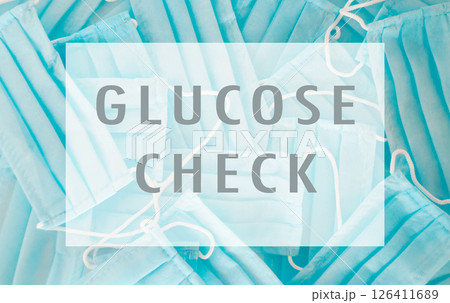 Blue sign with a white border that says Glucose Check with a pile of blue su 126411689