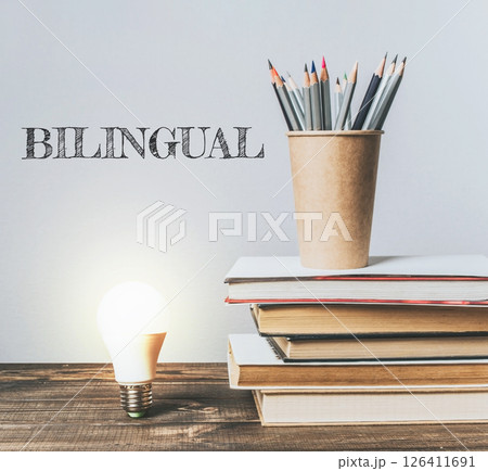 A stack of books with a pencil and a light bulb on top of them A stack of books with a pencil and a light bulb on top of them 126411691