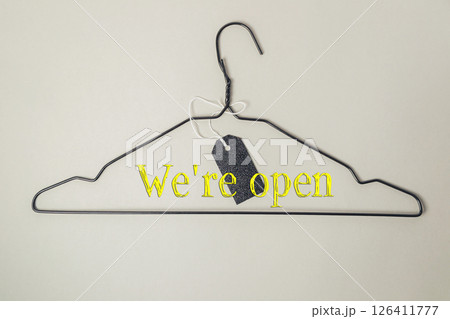 Clothes hanger with a tag on it that says We're open Clothes hanger with a tag on it that says We're open 126411777