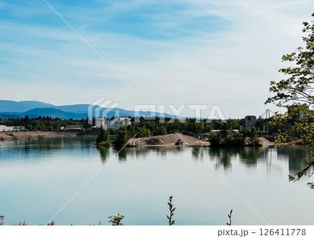 A calm lake with a few buildings in the background A calm lake with a few buildings in the background 126411778