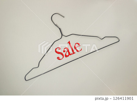 Metal clothes hanger with the word Sale written on it 126411901