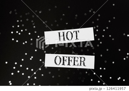 Hot offer is written on a black background with stars scattered around 126411957