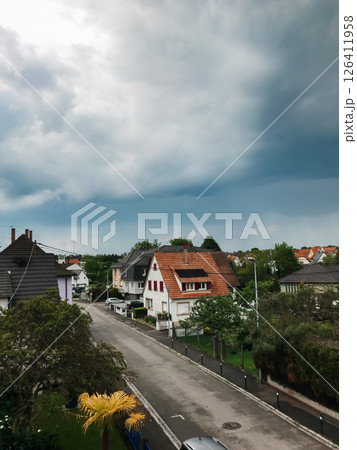 A street with houses and a cloudy sky 126411958