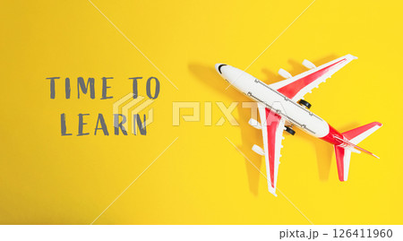 Toy airplane is on a yellow background with the words Time to Learn Toy airplane is on a yellow background with the words Time to Learn 126411960