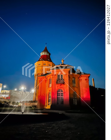 A building with a red roof and yellow trim is lit up at night A building with a red roof and yellow trim is lit up at night 126412027