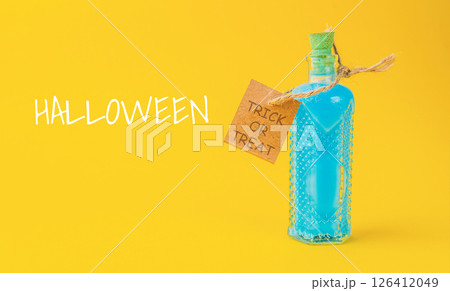 Bottle of blue liquid with a tag that says Halloween Trick or Treat 126412049