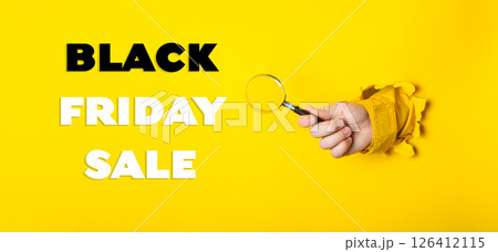 Hand holding a magnifying glass with the words Black Friday Sale written below Hand holding a magnifying glass with the words Black Friday Sale written below 126412115