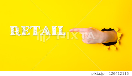 Hand pointing to the word retail on a yellow background Hand pointing to the word retail on a yellow background 126412116